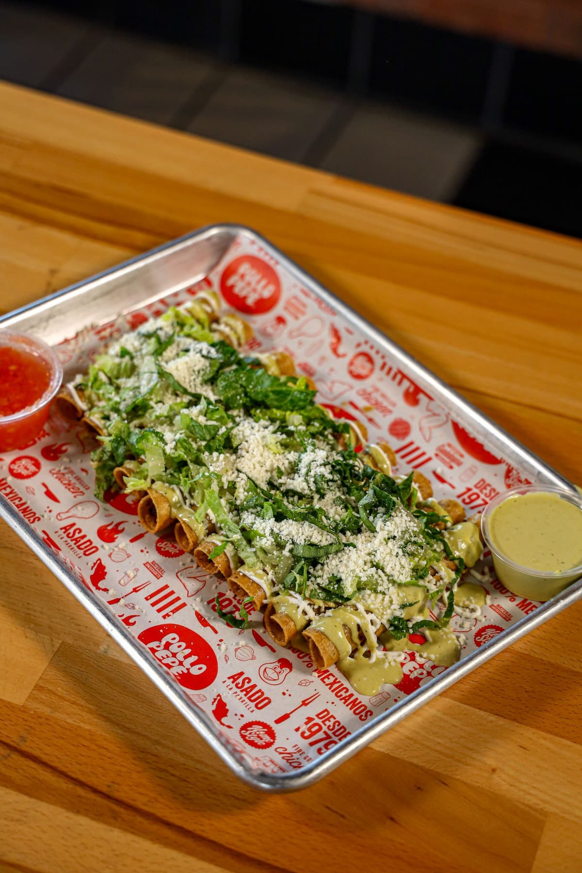 Chicken flautas topped with lettuce, Cotija and crema